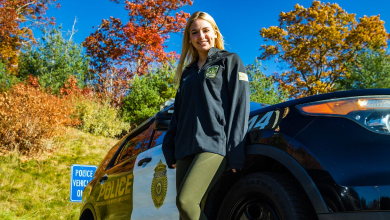 Sarah Carlozzi stands in front of a police cruiser