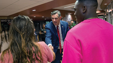 President Clark shakes hands with students
