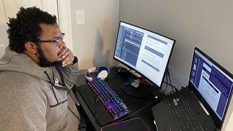 Jahmel Wint works at a computer desk.