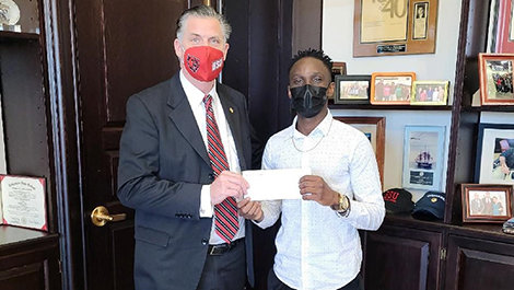 Dabana Intenque receives a scholarship check from President Clark