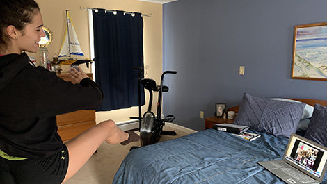 A student dances during a virtual class.