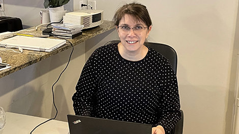 Elizabeth Englander sitting at a desk, working on her laptop