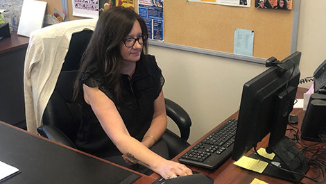 Diane Heath sits at a desk and moves a computer mouse.