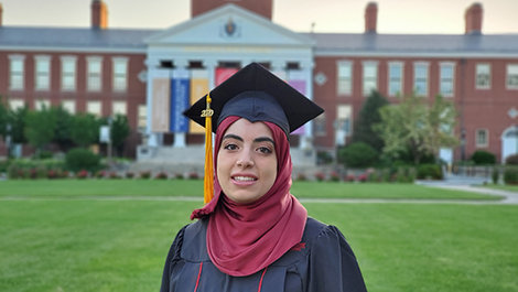 Hind Al Jurf in her cap and gown in front of Boyden Hall