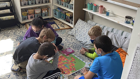Kids play the Kind Mind game while sitting in a circle.