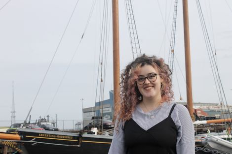 Carolyn King stands in front of an old whaling ship.