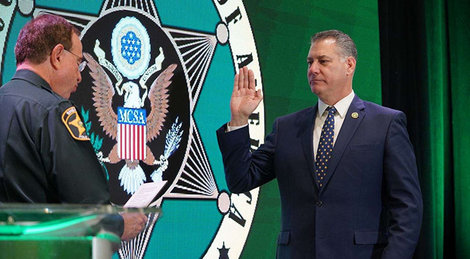 Peter Koutoujian, '83, right, is sworn in by outgoing Major County Sheriffs of America President Grady Judd.