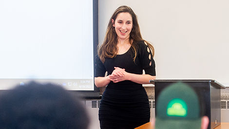 Sidita Kushi teaches a class in front of a white board.