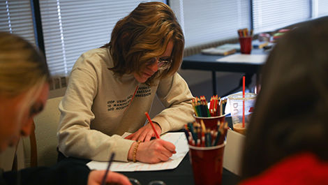 A student uses colored pencils to draw a mind map during a Life Design workshop.