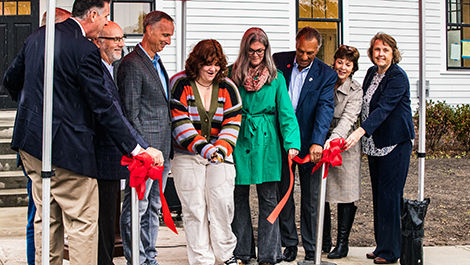 Jane Richard cuts a red ribbon in front of the Martin Richard Institute for Social Justice's new home/