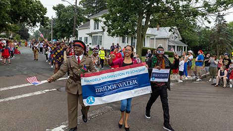 Mandela fellows carry a banner announcing the fellowship in the parade.