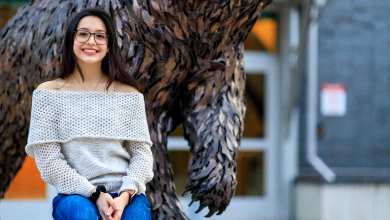 Paulina Aguilar sits in front of bear statue on BSU campus
