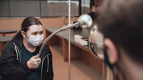 Students conduct a demonstration using a Van de Graaff generator.
