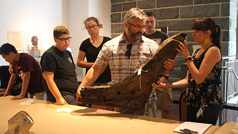 Calvin Mires lifts a timber from the Sparrow-Hawk onto a table.