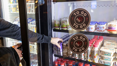 A student picks a drink out of a Bears-to-Go refirgerator.