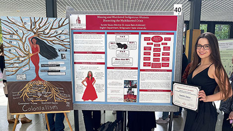 Sunnie Souza standing next to her research poster and painting