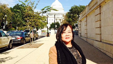 My Lan Tran stands o a sidewalk in front of the U.S. Capitol.