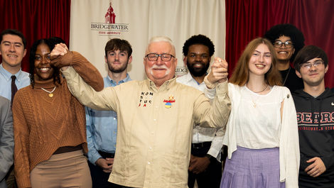 Students pose for a group photo and hold hands with President Walesa.