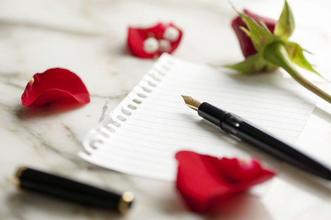 Roses and a pen on a piece of paper Roses and a pen on a piece of paper