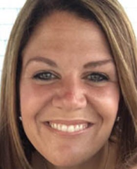close up headshot of Emily Holmes smiling with straight dark blonde hair