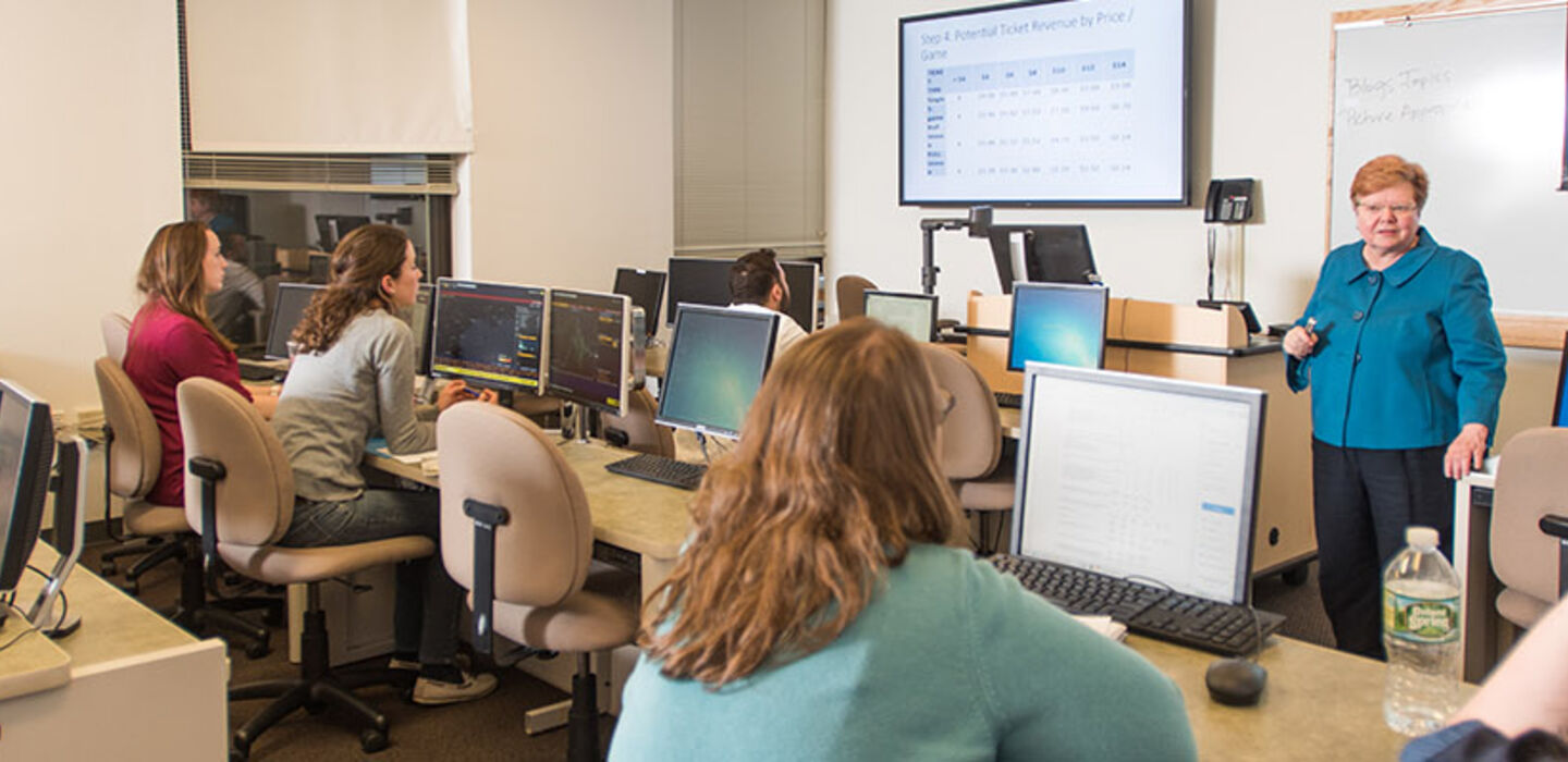Dr. Marian Extejt teaching a management class while students look at her and their computer screens