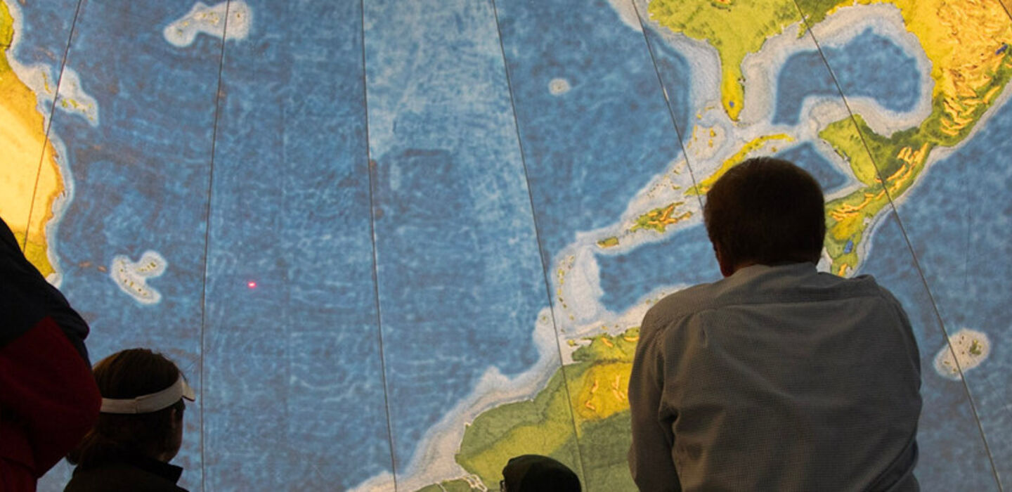 Dr. Vernon Domingo and a group of people inside the EarthView Globe looking up 