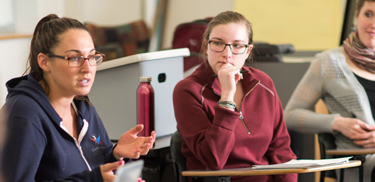 BSU students and Sociology professor sitting in a circle of desks in the classroom having a discussion
