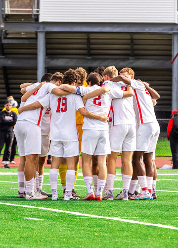 BSU men's soccer team in a huddle during championship