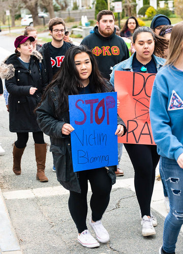 Students holding signs and marching in Take Back the Night rally