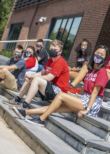 Masked students gathered on some steps